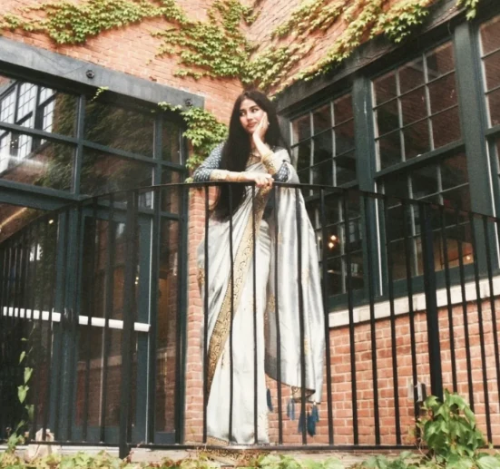 Rafa in a silver saree near ivy-covered brickwork