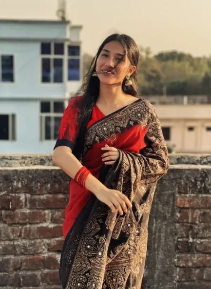 Rafa in a red and black saree outdoors